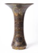 An Islamic brass copper and silver inlaid vase: of waisted form and flared rim,
