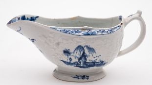 A Lowestoft blue and white sauceboat and a similar mug: the sauceboat with moulded floral and