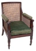 A Regency mahogany bergere library armchair:, with a reeded frame,