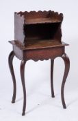 An 18th Century oak Cheveret:, the shelved superstructure with a shaped three quarter gallery,