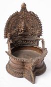 A 19th Century Indian bronze pooja oil lamp: the arched back decorated with Gaja Laskshmi Hindu