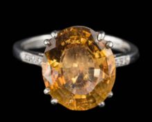 A platinum, topaz and diamond dress ring: the oval topaz approximately 13mm long x 11.