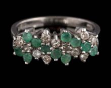 An emerald and diamond cluster ring: with rows of circular stones ring size N.