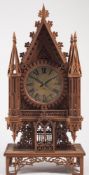 A Gothic mantel clock constructed from cigar boxes: the silvered dial with black Roman numerals,