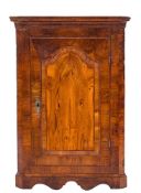 An early 18th Century walnut hanging corner cupboard:, with a moulded cornice and canted angles,