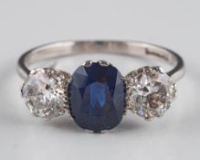 A sapphire and diamond three-stone ring: the central oval sapphire approximately 8mm long x 7mm