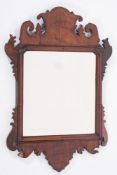 A 19th Century walnut fret cut mirror:, the rectangular bevelled plate within a moulded surround,