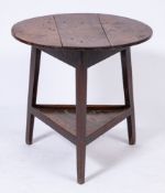 An early 19th Century oak circular cricket table:, on triangular splayed legs,