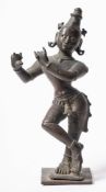 An Indian bronze figure of Krishna playing a flute: mounted on a square base, lacks flute 18.