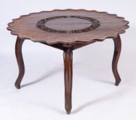 A 19th Century Indo Colonial carved wood centre table:, the flowerhead top,
