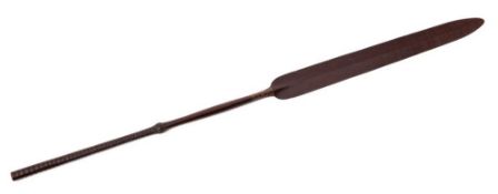 A carved hardwood South Pacific paddle: the spear-shaped blade on a slender shaft with ribbed