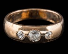 A gold and three-stone diamond band: with graduated old-cut diamonds estimated to weigh a total of