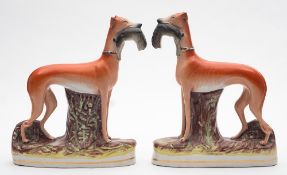 Two pairs of Victorian Staffordshire pottery figures of greyhounds: one pair decorated in iron-red,