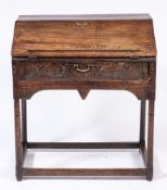 A 17th Century oak desk:, the hinged sloping fall fitted with a ledge enclosing a fitted interior,