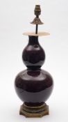 A Chinese sang-de-boeuf ormolu-mounted double gourd vase: covered in a rich ox-blood glaze with