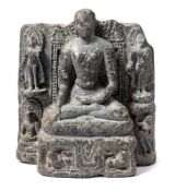 An Indian dark stone stele of a Buddha: seated in dhyanasana, before a mandorla,