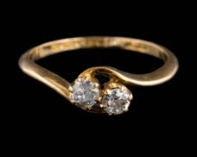 An 18ct gold and diamond two-stone cross-over ring: set with round old brilliant-cut diamonds