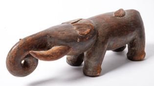 An African carved wooden head rest: in the form of an elephant, 39cm long.