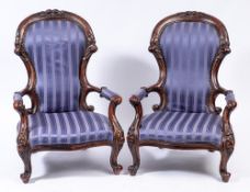 A pair of Victorian carved beech lady's and gentleman's armchairs:,