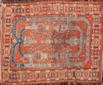 A Kurdish rug:, the rust field with a geometric design in pastel blue colours,