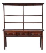 A late 18th Century oak dresser:, the open shelved superstructure with a moulded cornice,
