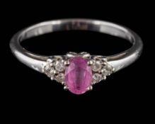 A pink sapphire and diamond ring: the oval pink sapphire in four-claw setting between diamond