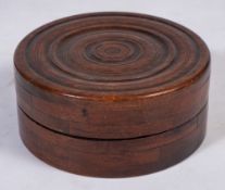A 19th Century mahogany circular box:, with turned moulded cover, 22cm (8 3/4in) diameter.