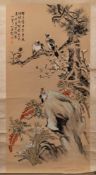 A Chinese scroll painting, signed Ding Bao: of birds perched on a flowering tree and rockwork,