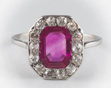 An Art Deco ruby and diamond cluster ring: the central octagonal ruby within surround of round