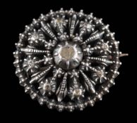 A silver circular, diamond chip brooch: of pierced design approximately 28mm diameter.