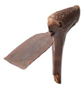 A carved tribal adze: the steel blade inserted into a wood shaft,