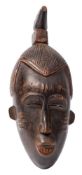 Guro, Ivory Coast, a carved wood mask: 40cm high.