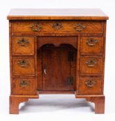 An early 18th Century walnut and cross and feather banded kneehole desk:,