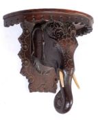 An Indian carved wood half round wall mounted china bracket:,