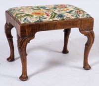 An early 18th Century walnut stool:, with a rectangular upholstered slip in seat on cabriole legs,