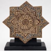A Persian star shaped pottery tile: of Kashan type the centre painted in brown and white with a