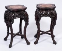 A pair of Chinese carved hardwood jardiniere stands:, the quatrelobe tops with beaded edges,