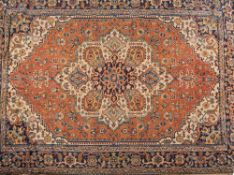 An Indo Persian carpet:, the rust field with a central ivory geometric flowerhead pole medallion,