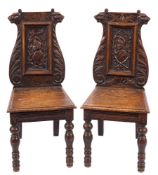 A pair of 19th Century Flemish carved oak hall chairs:,