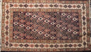 A Shirvan rug:, the shaded field with an all over design of stellar and hooked geometric medallions,