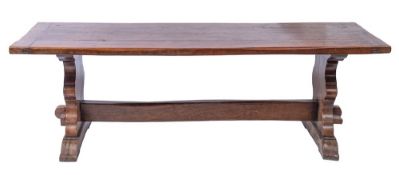 An oak dining table of refectory type:, with a rectangular cleated plank top,