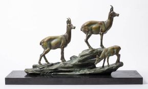 An Art Deco period patinated metal figure group: of three mountain goats on a rocky outcrop,