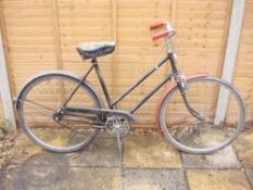 A mid 20th century Raleigh lady's bicycle: black step through frame, solid bar brakes,
