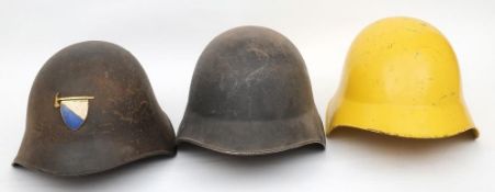 Three Swiss M1918/43 pattern steel helmets: one undecorated, one in yellow,