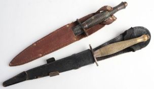 Two Fairbairn Sykes pattern knives: one with chequered brass grip in black leather scabbard,
