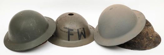 A group of four Brodie pattern steel helmets: one in relic condition (4)