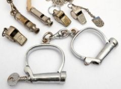 A pair of Hiatt handcuffs: together with five various whistles: including an Acme Referee and an