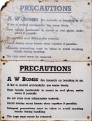 Two WWII enamel signs 'Precautions A W Bombs': black text on white ground, 20.5 x 30.