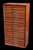 A scratch built stained pine collector's cabinet of eighteen drawers with brass handles,