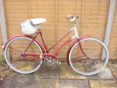 A 1960s Triumph 'Palm Beach' lady's bicycle: two tone red & white step through frame with remains